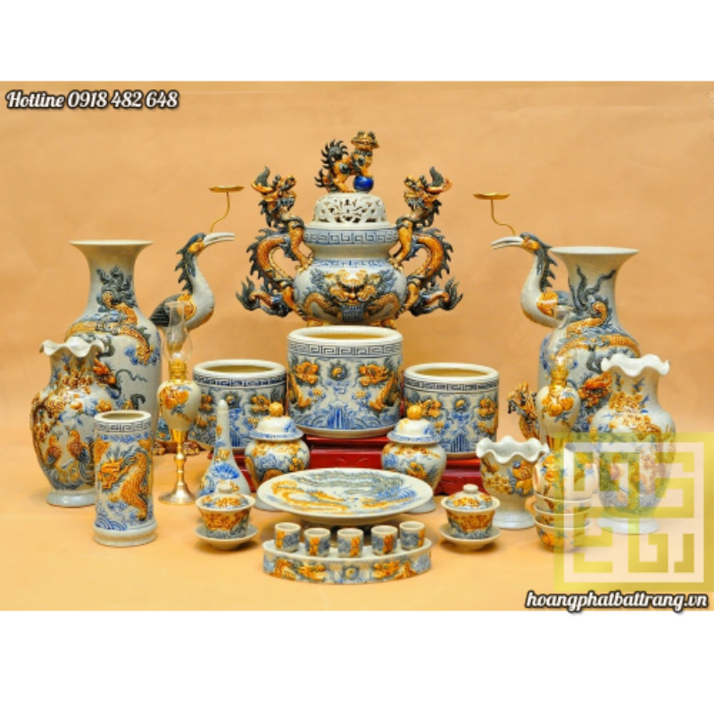 Bộ bát hương thờ gia tiên bằng gốm sứ Bát Tràng truyền thống, đặt trên bàn thờ gỗ nâu sang trọng, được trang trí bằng hoa sen và nến.